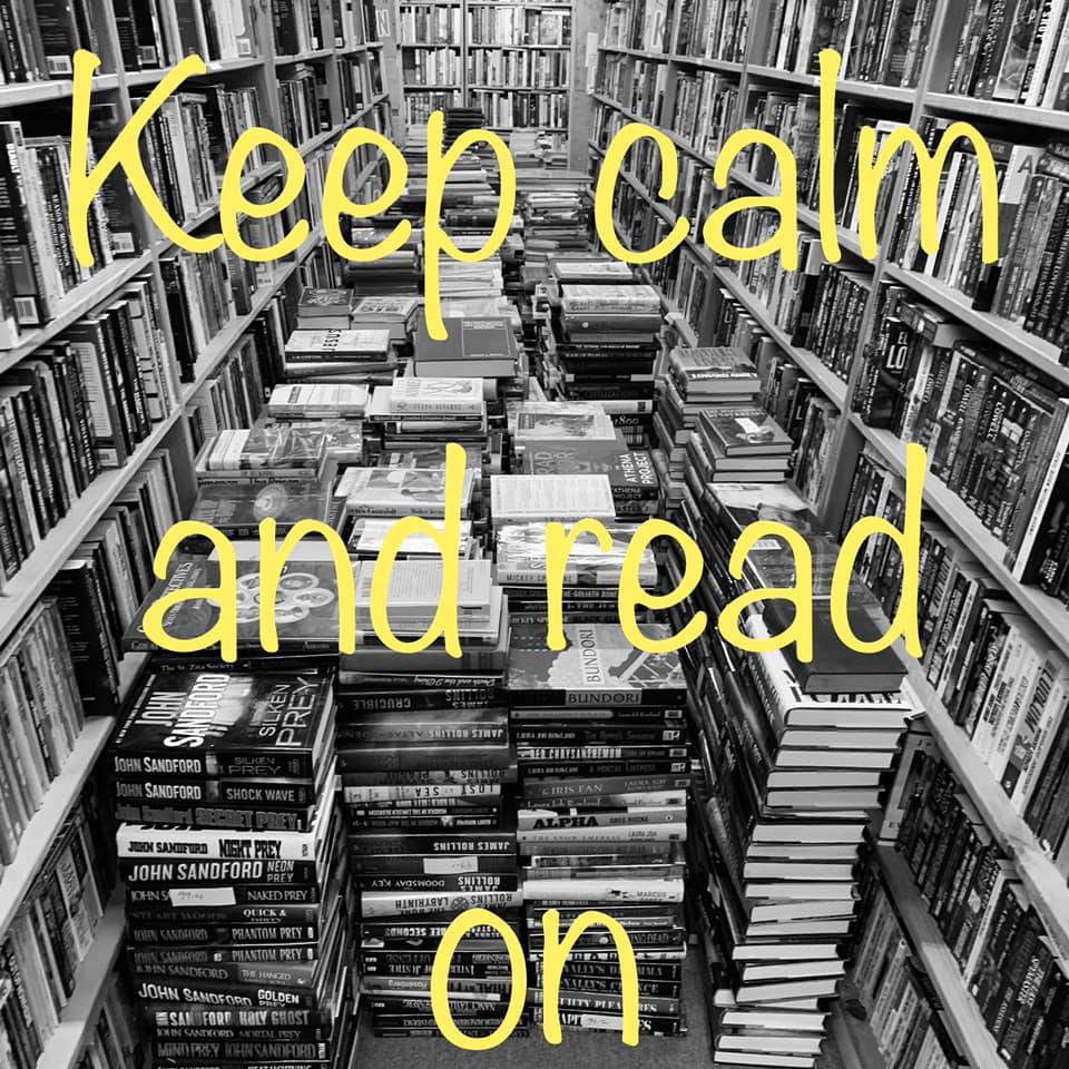 Keep calm and read on displayed over large stacks of books